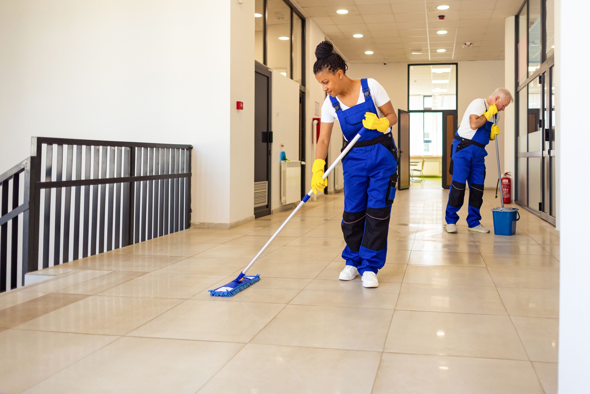 Janitors cleaning the  floor in school hallway